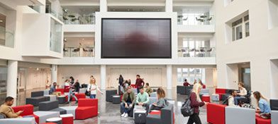 An educational facility’s atrium with students socialising.