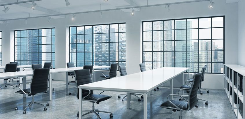 An empty white. modern office with large windows helping to illustrate StanLil’s interior office design and build services.